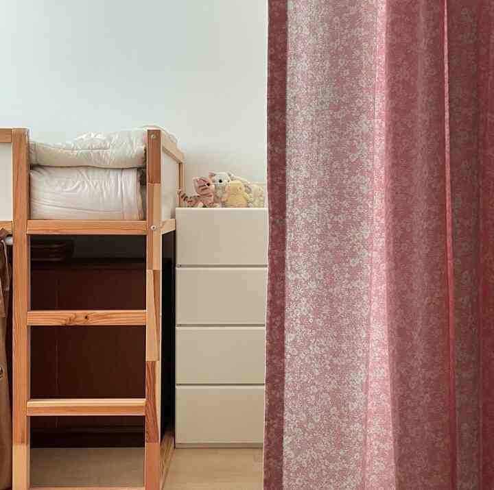 白い壁と木目調の二段ベッド、収納棚が配置された暖かく落ち着いた子供部屋。