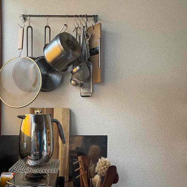 Natural color wall and wood tone kitchen utensils in a kitchen space, featuring a French press coffee maker for a cozy home cafe atmosphere