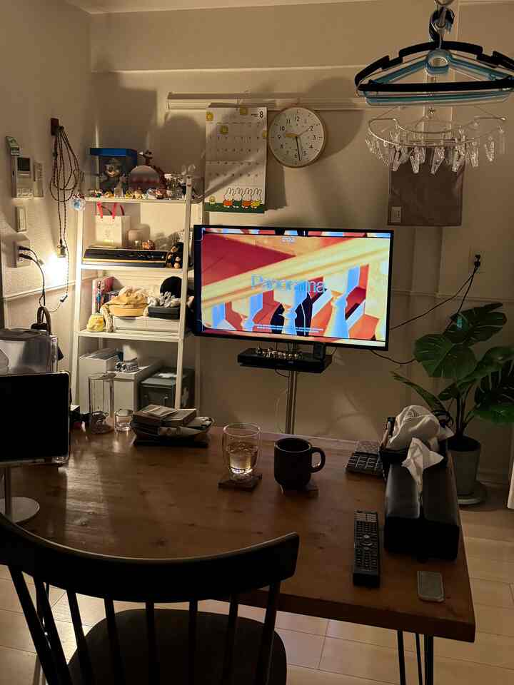 A cozy single household living room with natural wood tones and white walls, featuring a dining table and TV stand