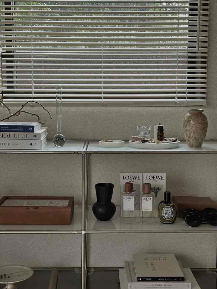 Modern space with white and transparent tones featuring metal shelving and wooden accessories creating a clean, minimal atmosphere