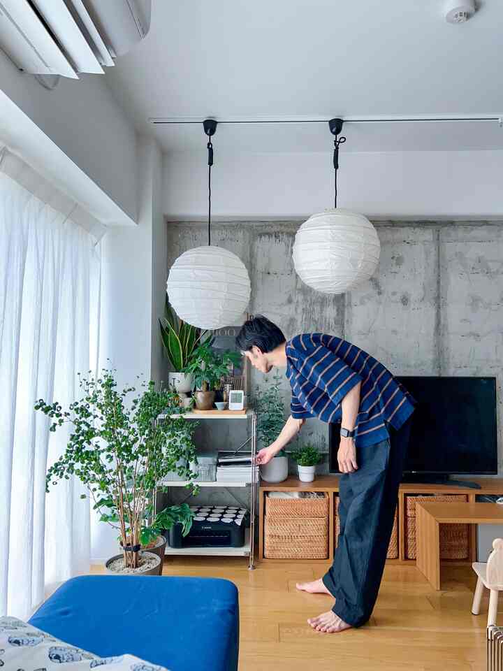 白と緑のトーンのリビング、植物とシンプルな家具が配置された雰囲気のあるナチュラルな空間