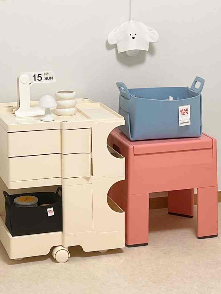 ベージュとコーラルピンクのトーンの収納アイデア空間、ミッドセンチュリーモダンスタイルのキャビネットとスツールが配置された印象的なインテリア