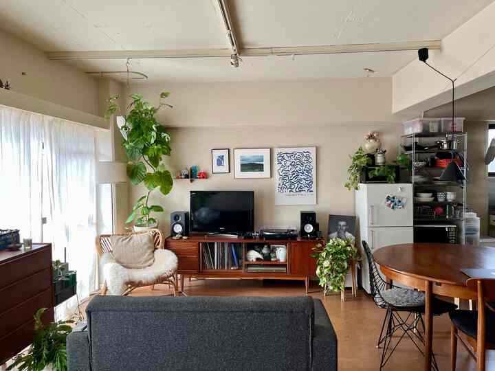 ナチュラルなブラウン調のリビングとダイニング、木製家具と緑の植物が配置された雰囲気のあるインテリア