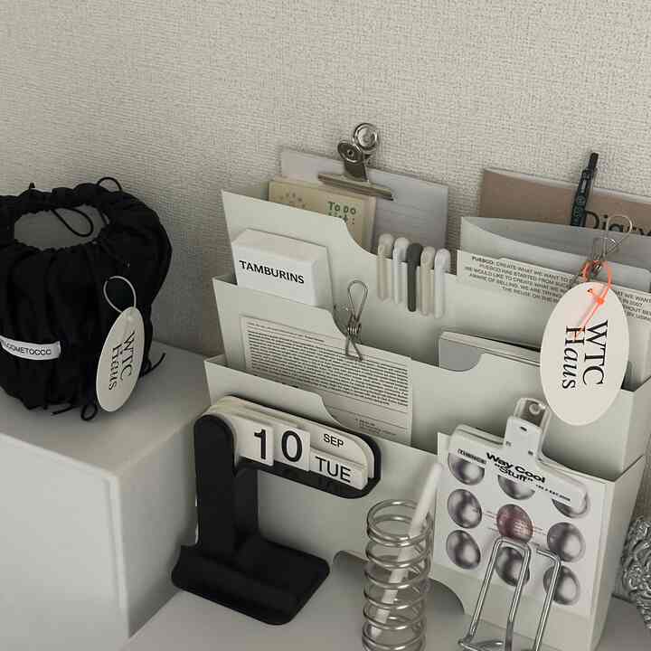 Monotone white and black home office desk setup featuring neat storage ideas with a minimal aesthetic