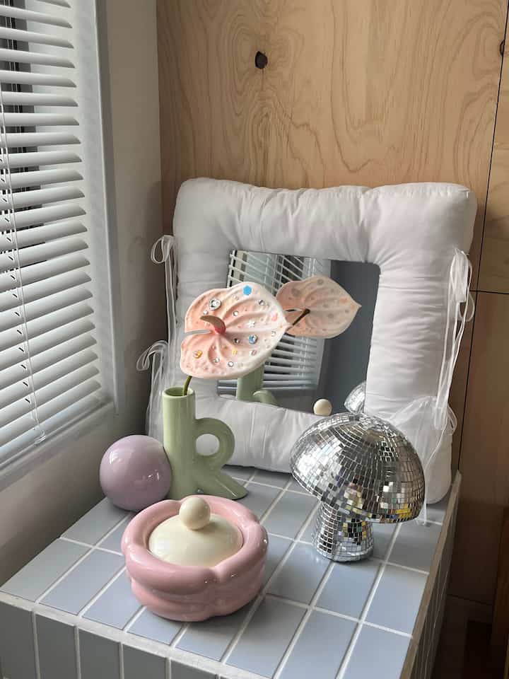 白とパステル調の海外インテリア、小物が配置された木目の背景の空間