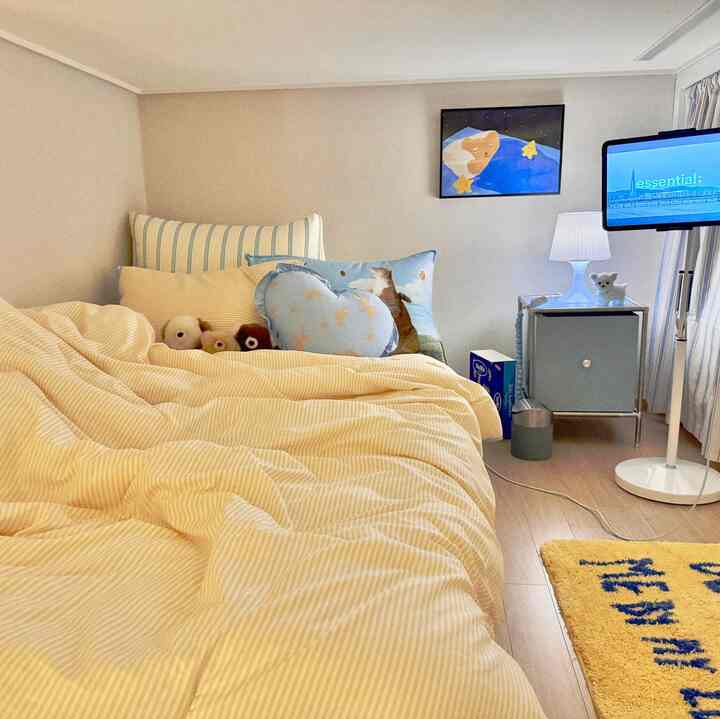 ベージュ色調の寝室、猫モチーフのクッションとかわいい小物が配置された温かみのある空間