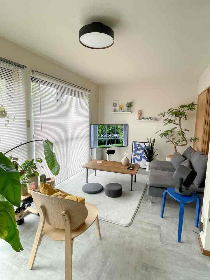 白とグレーのトーンが広がる6帖のリビング、モダンなソファと木製チェアが配置された自然で清潔感のあるインテリア