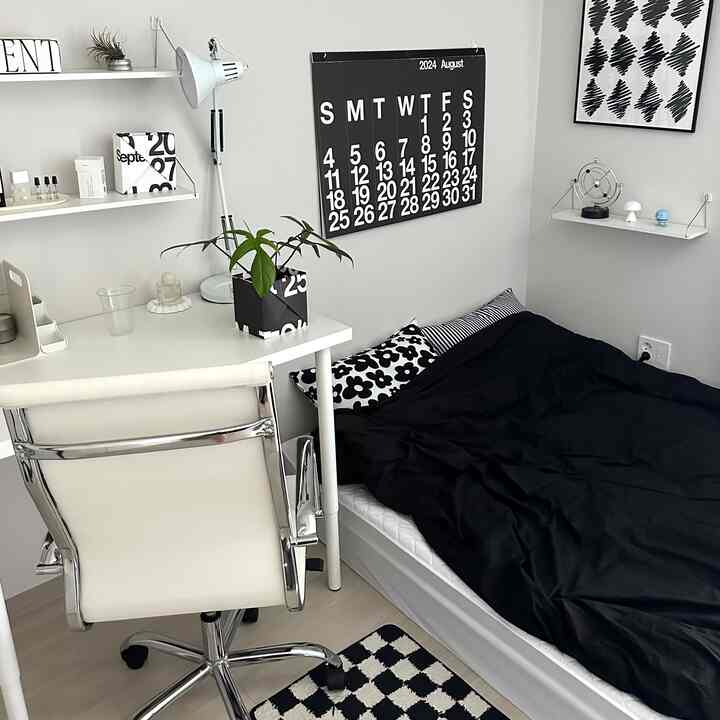 黒と白のトーンが調和するモダンで清潔感のある寝室、白いデスクと椅子、黒い寝具が配置された空間