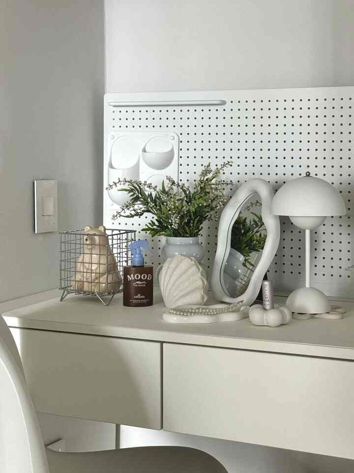 ホワイトトーンの化粧台空間、卓上鏡とさまざまなアクセサリーが整ったミニマルなインテリア