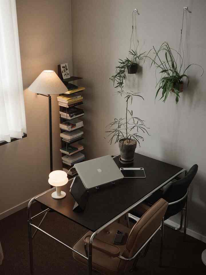 チャコール色のモダンなホームオフィス、黒い机と椅子、植物が配置された落ち着いた作業空間