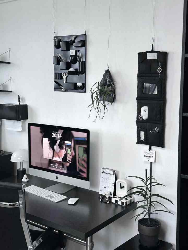 黒と白のトーンでまとめられたホームオフィス、アイマックと整理されたデスク用品が配置されたモダンなインテリア