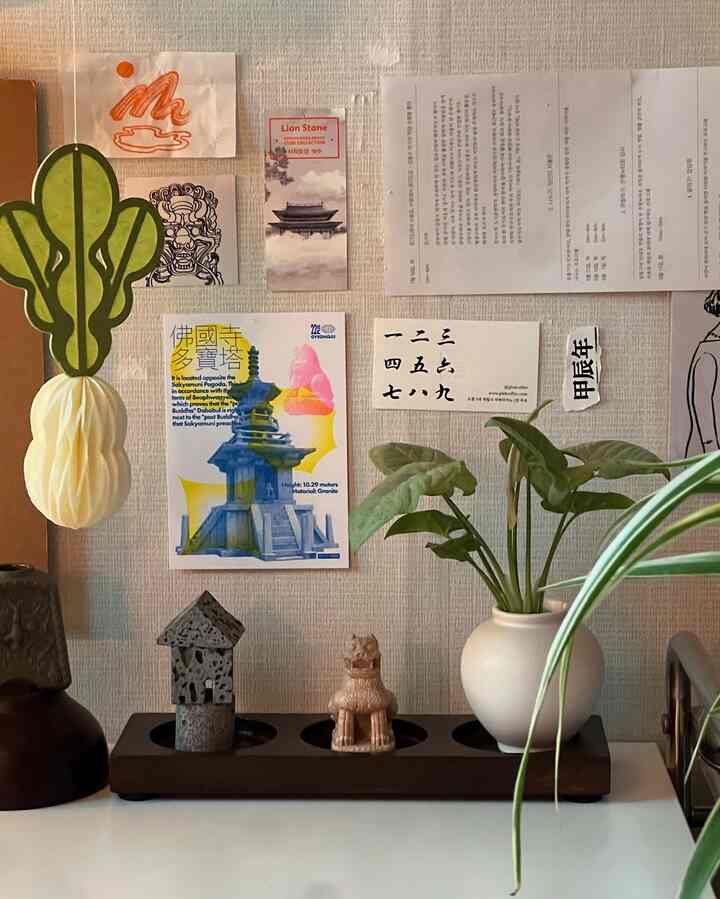 Natural-toned wall featuring Korean-themed decor and plants arranged on a cozy desk area