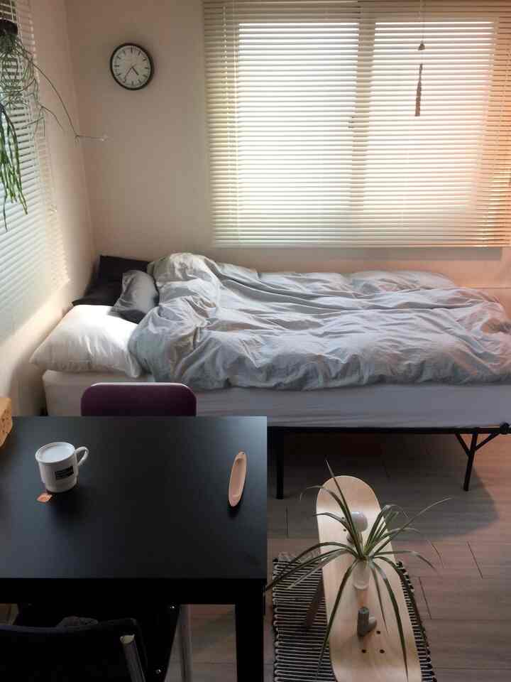 Bright-toned bedroom space featuring a bed and black desk, creating a cozy and functional single household room