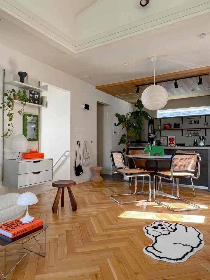 白とナチュラルな木目調のダイニングルーム、ラタンチェアとペンダントライトが配置された雰囲気のある空間