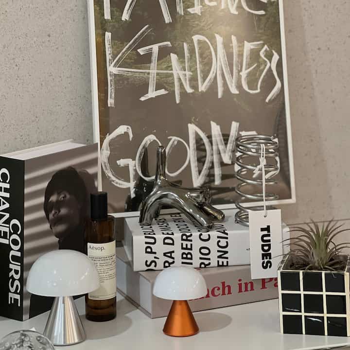 ホワイトとブラックのトーンが広がるリビングのモジュール棚に、中世モダンスタイルのインテリア小物とオブジェが印象的な空間