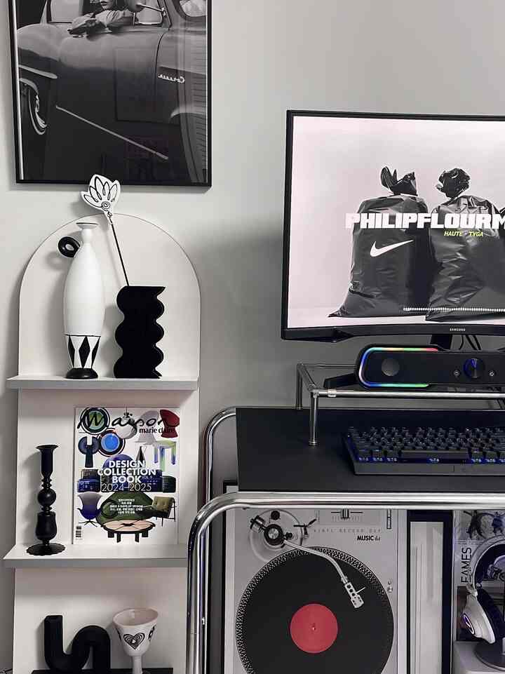 ホワイトの壁とシルバーのメタルデスク、黒白のモノトーンオブジェが配置されたモダンなホームオフィス空間