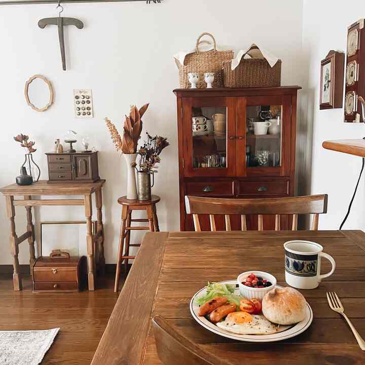 Natural brown-toned dining room featuring wooden dining table, chairs, and cabinet with a warm atmosphere