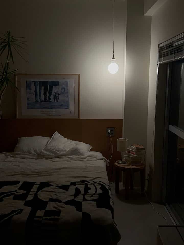 白と茶色のトーンの寝室、中央のペンダントライトが雰囲気を演出するモダンな夜の空間