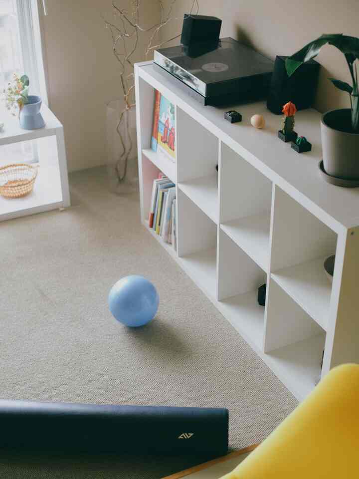 白を基調としたワンルーム、ピラティスマットと青いエクササイズボールが配置されたシンプルで落ち着いた雰囲気のインテリア
