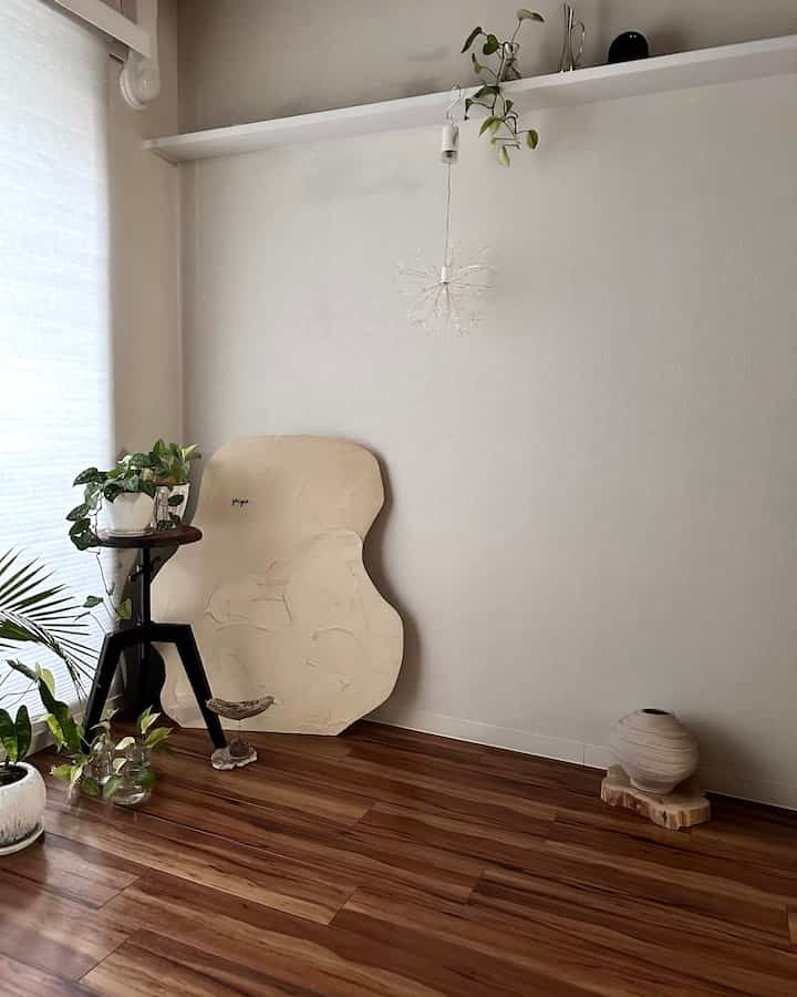 ナチュラルカラーと木目調の小さなリビング、植物とスツールが配置されたモダンなインテリア