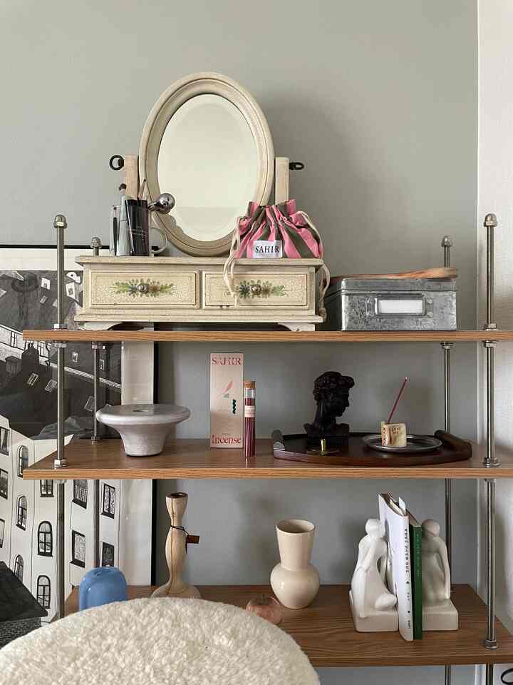 Living room shelf in beige and wood tones featuring a vanity dresser and decorative objects creating a natural atmosphere