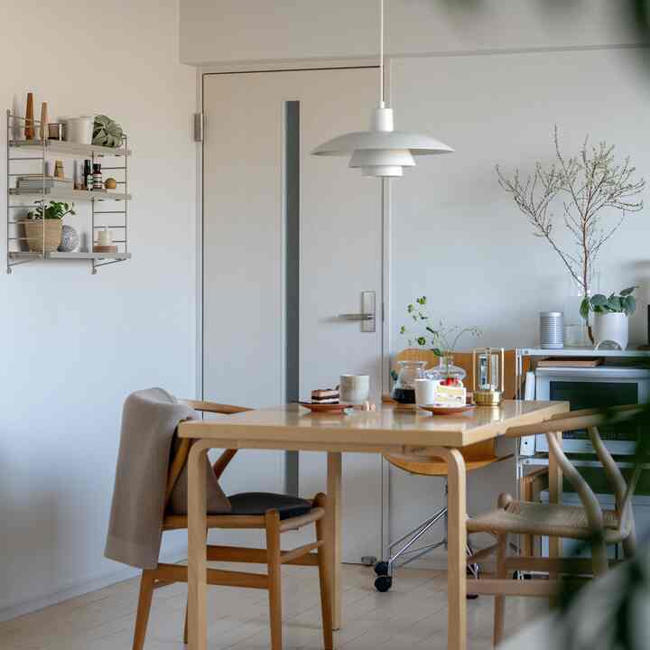 ナチュラルな色調のダイニング、シンプルな木製テーブルと椅子が配置された雰囲気のあるおうちカフェの空間