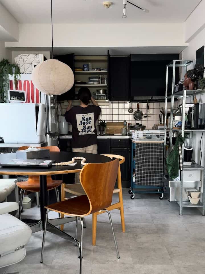 A compact dining room in white, black, and brown tones featuring a simple modern dining table and chairs for a single household