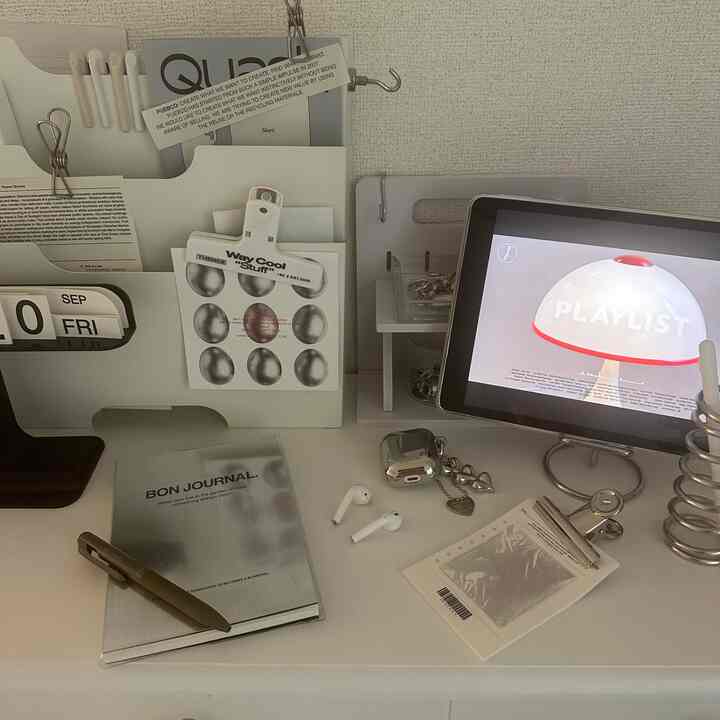 白を基調としたシンプルで清潔感のあるホームオフィス空間、タブレットと書類整理ラックが配置されている