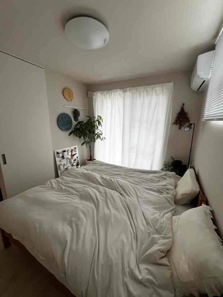 ホワイトとウッドトーンが調和した落ち着いた5.5畳の寝室、シングルベッドがゆったりと配置された自然な雰囲気のインテリア