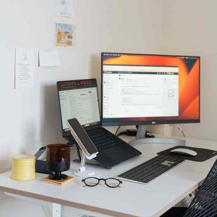 白を基調としたワークスペース、ノートパソコンとモニターが配置されたシンプルで清潔感あるインテリア