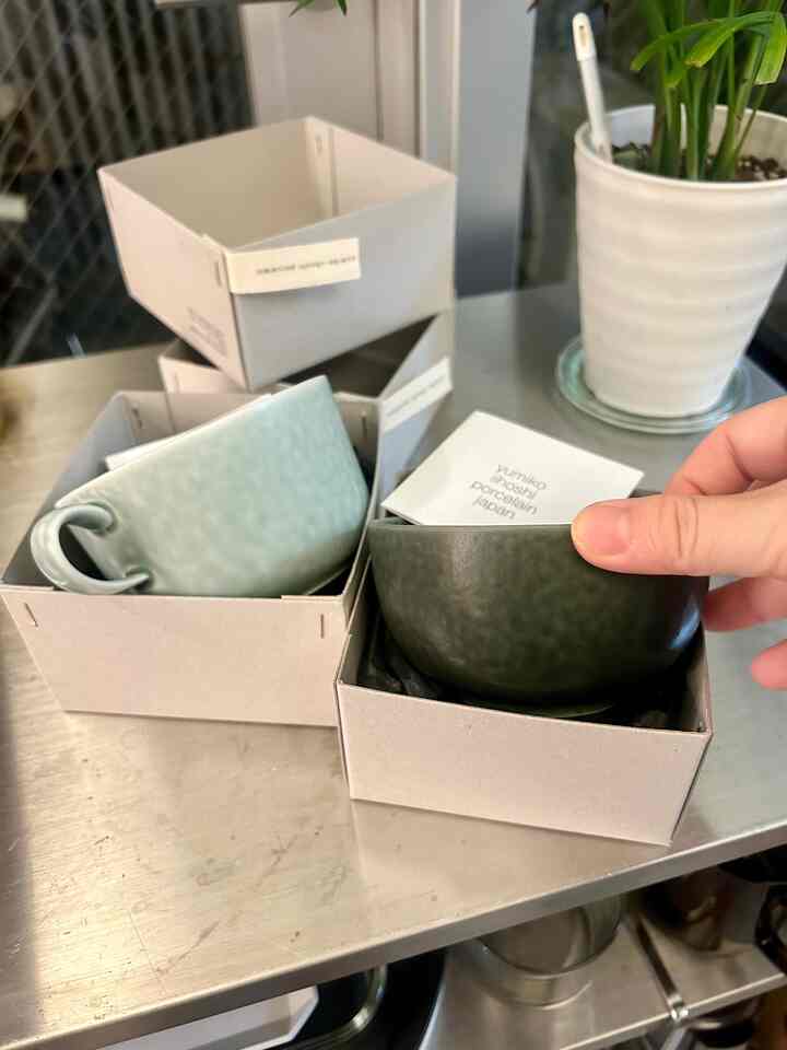 グレーの金属製テーブルの上に、日本風の磁器の茶碗二つが箱に入って置かれている様子