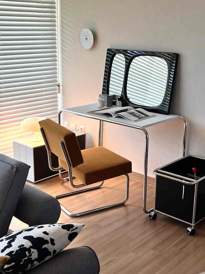 ナチュラルな木目調フローリングと明るい白い壁が調和したリビング、ミッドセンチュリーモダンの椅子とテーブルランプが配置された雰囲気のあるインテリア