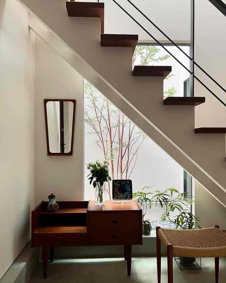 Cozy Scandinavian living room corner featuring natural wood tones and greenery with minimalist decor