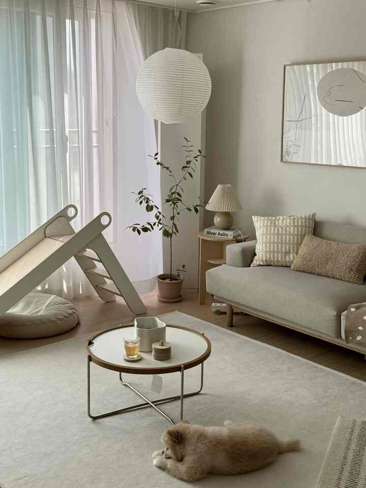 Beige and natural tone living room featuring a children's slide and a pet dog in a cozy atmosphere