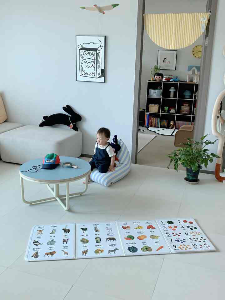 ナチュラルカラーのリビング、ベビー用ビーズクッションとビギニングテーブルが配置された温かみのある空間