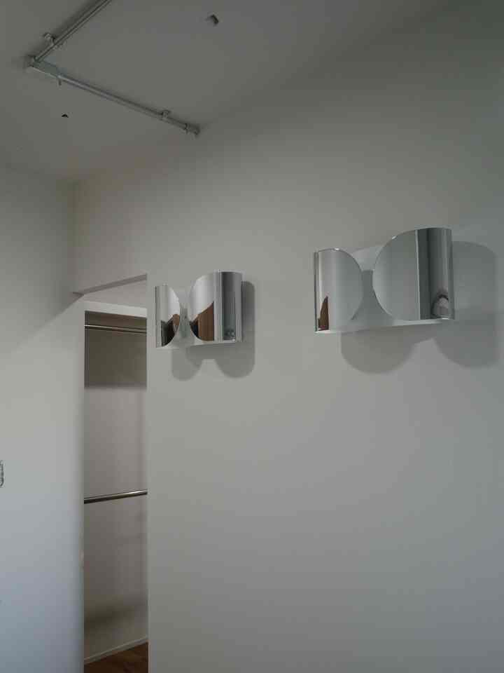 Modern entrance interior featuring white walls and chrome silver wall sconces with minimalistic design