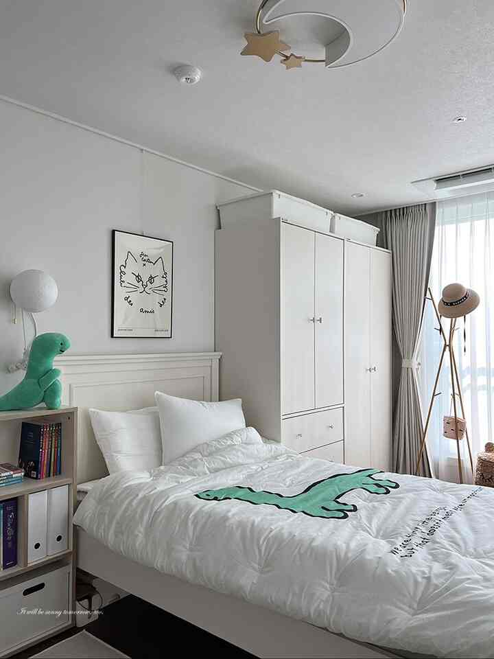 White and natural toned kids' room featuring dinosaur character bedding and neat furniture creating a cozy space