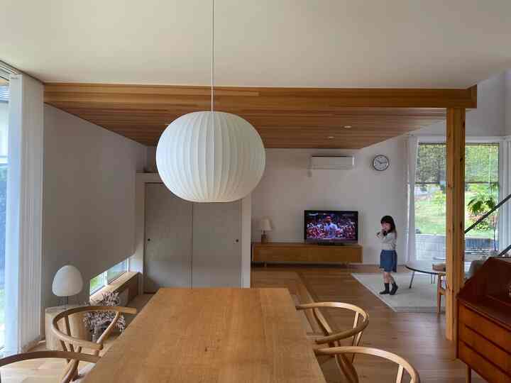 白と木目調が調和したリビングとダイニング、印象的なペンダントライトが置かれた雰囲気のある空間