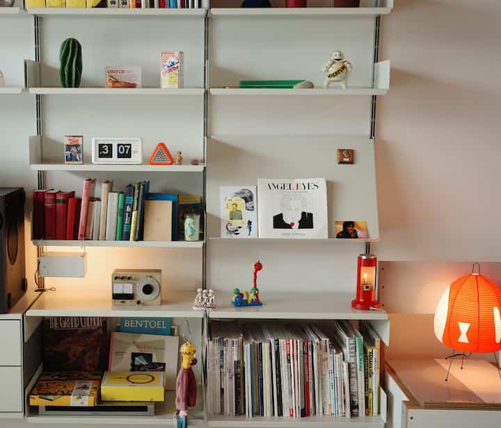 白と赤の色調が調和するシンプルな北欧風の棚が配置された雰囲気のあるインテリア