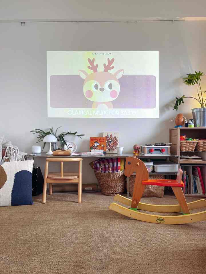 ベージュのラグと木目調家具が配された子供部屋、玩具と机があり、ナチュラルで温かみのある雰囲気のあるインテリア