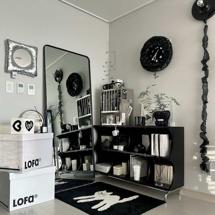 Modern study space with black and white tones featuring a cat-shaped rug and sleek storage cabinet