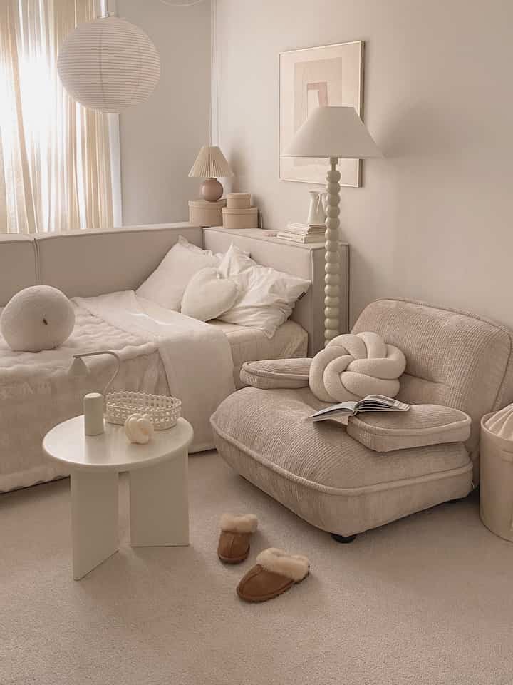 ナチュラルな色調でシンプルな寝室兼リビング、ソファベッドとフロアランプが配された雰囲気のあるインテリア