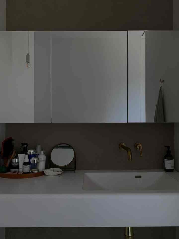 ホワイトとブラウンのトーンのバスルーム、造作洗面台とミラーボックス、ペンダントライトが調和したモダンなインテリア