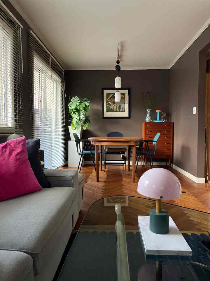 Brown and gray toned living room featuring gray sofa and pink table lamp in a warm modern setting