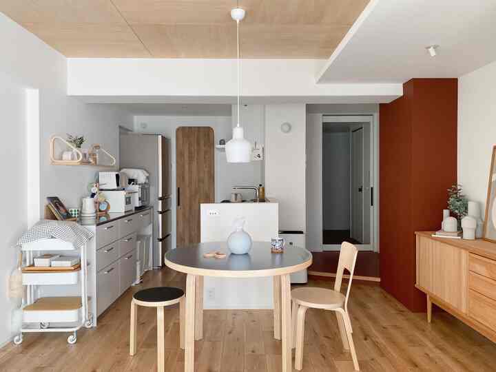 Natural wood tones and white-themed kitchen and dining space, featuring simple furniture with a vintage touch