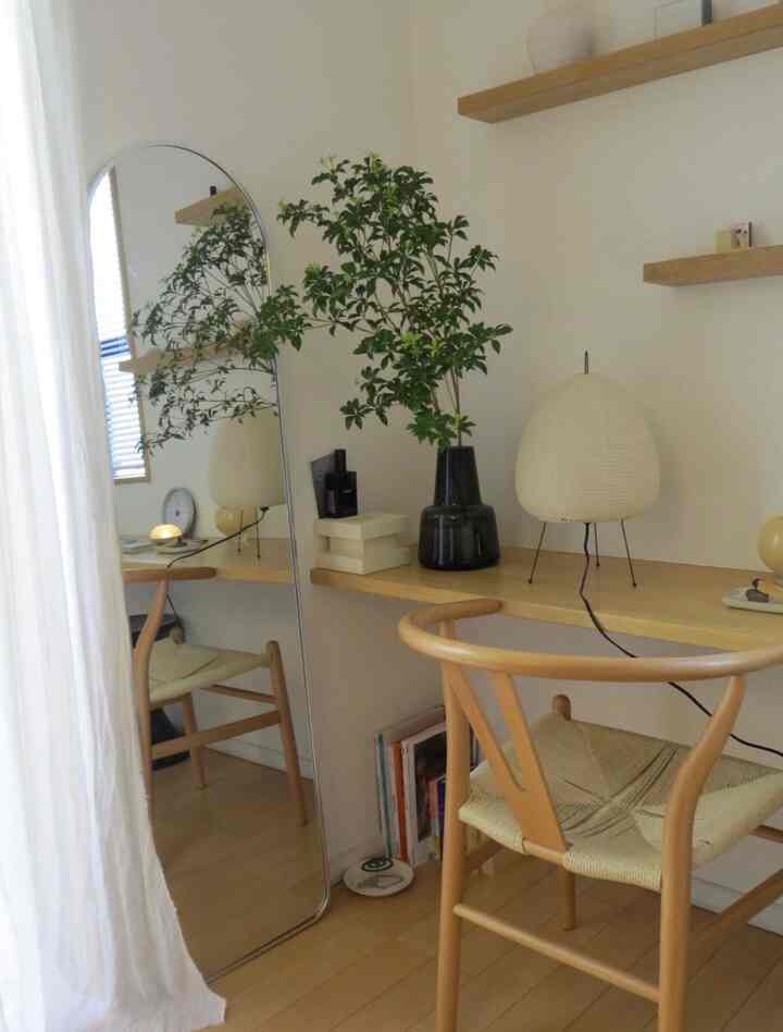 ベージュと木目調の小さなワークスペース、アーチミラーと木製チェア、植物が配置されたナチュラルな雰囲気のインテリア