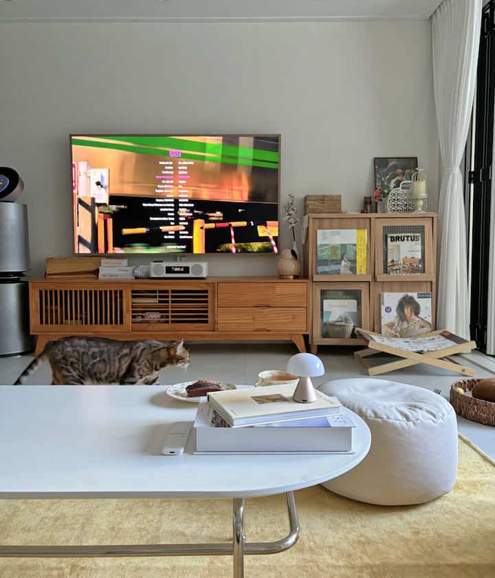 ホワイトと木目調のナチュラルなリビング、テレビ台とテーブルランプを置いたシンプルモダンなインテリア