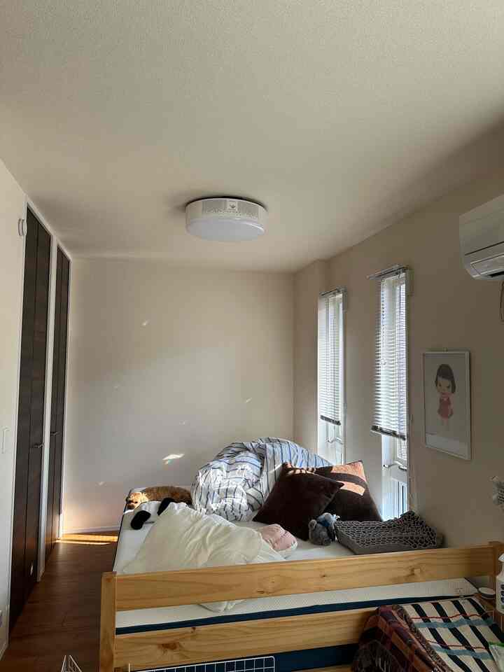 Natural wood tones and white walls in a bedroom, featuring a cozy wooden bed with pillows and a dog resting on it