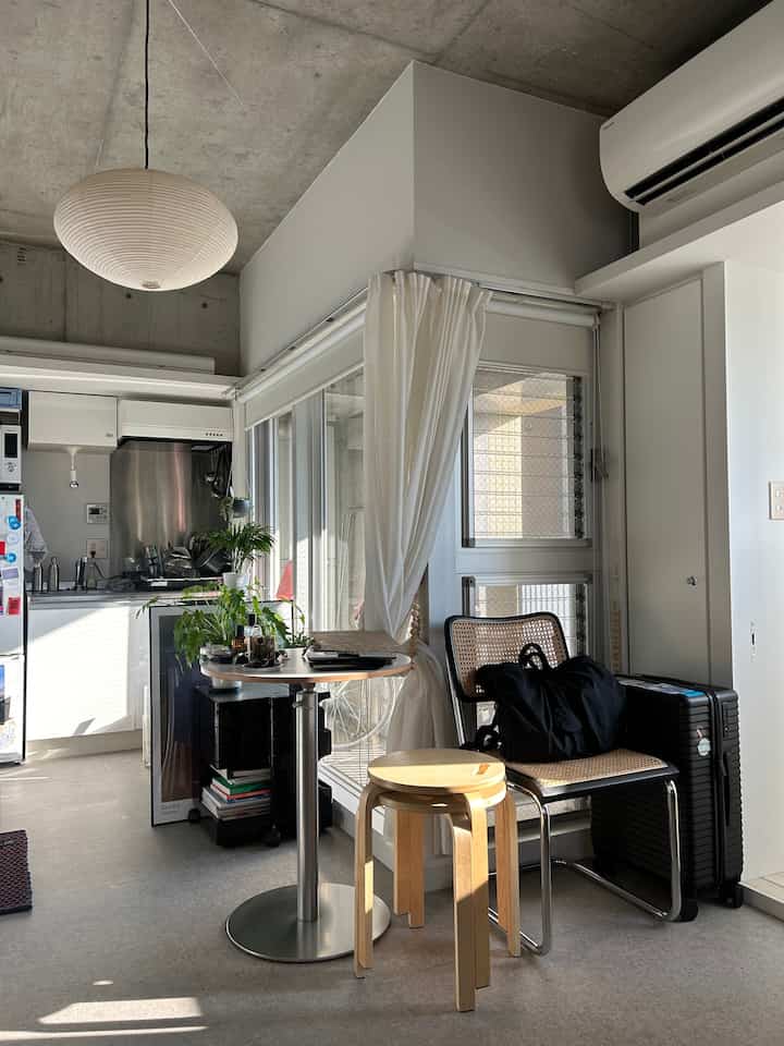 White and natural tone studio apartment with kitchen and dining area, simple and clean atmosphere