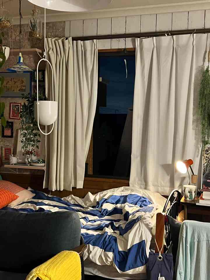 白と青の色調が調和する寝室、ベッドとカーテンが配置された雰囲気のある韓国インテリア